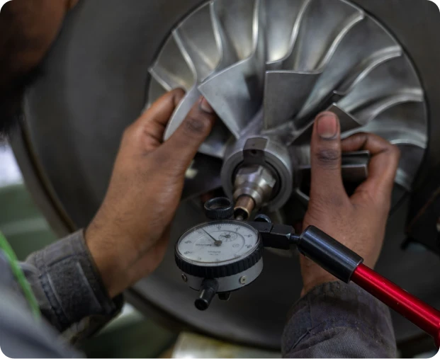 A technician ensures balance in turbocharger components at Majestic Engineering.